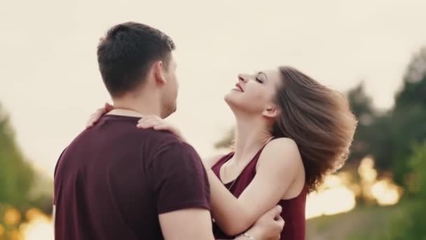 Young lovers stand in front of each other. They smile, man gently touches her hair, woman shakes hair. Slow mo — Stock Video