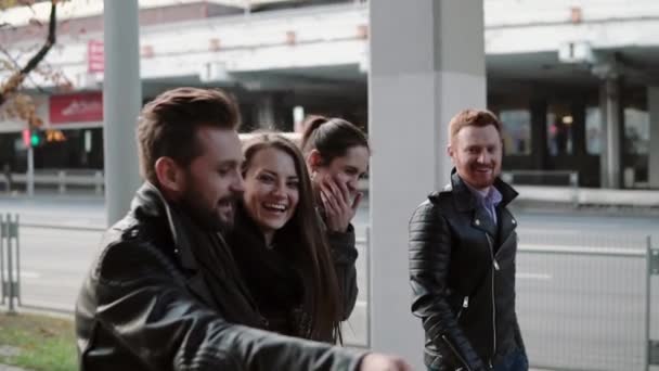 Due belle ragazze e due bei ragazzi ridono allegramente mentre camminano in città. Steadicam sparato, lento mo — Video Stock