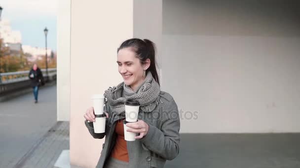 Twee mannen en twee vrouwen tijd in de stad. Een mooi meisje brengt koffie aan haar vrienden. Slow mo, steadicam schot — Stockvideo