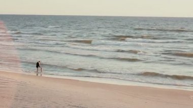 Yüzme gövdeleri ve onun yürümeye başlayan çocuk ile yüzmeye gidiyor t-shirt giyen bir kadın uzak bir görünümünü.