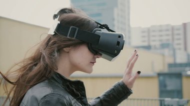 Esmer kadın kız saç sallayarak ile 3d sanal gerçeklik kulaklık çatıda kullanılır. 4k