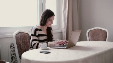 Güzel gülümseyen kadın parlak bir yemek dizüstü bilgisayar kullanarak.