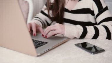 eller genç kadının kullandığı bir parlak yemek dizüstü bilgisayar.