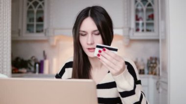 Plastik kredi kartı alışveriş online laptop ile çekici genç gülümseyen kadın kullanır.
