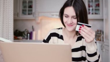 Çekici genç gülümseyen kadın plastik kredi kartı alışveriş online ile dizüstü bilgisayar kullanır. sağdaki kaydırıcıyı