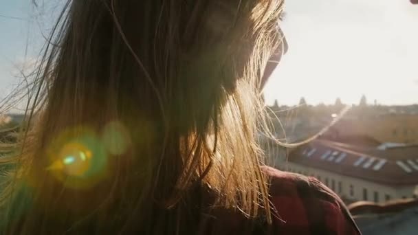 Primo piano di giovane donna e uomo guardando la città al tramonto in piedi sul tetto della casa . — Video Stock