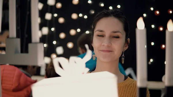 Молодая привлекательная брюнетка в магазине выбирает лампы коробки огни, рождественский декор . — стоковое фото