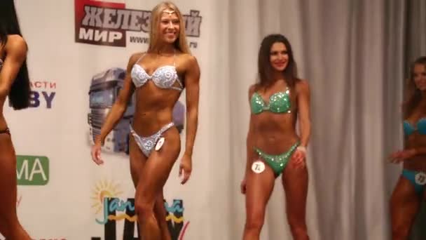 Wit-Rusland. Mogilev. 18 April 2015. Slanke vrouwelijke bodybuilder poseren in bikini, fitness competitie — Stockvideo