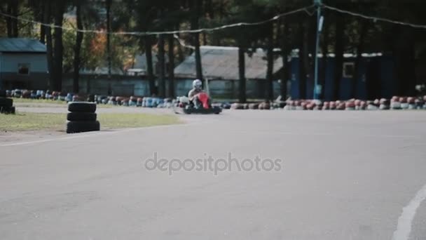 Deux conducteurs sur une piste de go-kart se déplacent dans la caméra et la passent. Course de karting . — Video