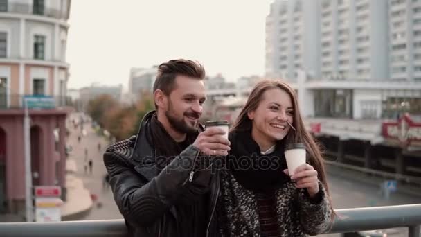 Twee gelukkige jonge mensen hebben plezier. Knappe jongeman en mooi meisje lachen vreugdevol, afhaalmaaltijden koffie houden. — Stockvideo