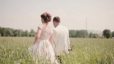 Bir kaç içinde aşkımız için düğün gününde elele bir buğday alanda yürüyüş geri. Güzel düğün kıyafetleri