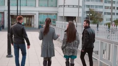 İnsanlar genç bir köprü üzerinde. İki güzel kız ve iki yakışıklı genç adam konuşmak üstünde belgili tanımlık gitmek. Mo yavaş, arkadan görünüm, steadicam vurdu