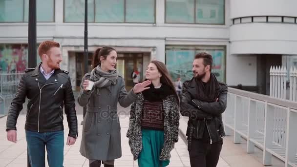 Jóvenes en un puente. Dos chicas guapas y dos jóvenes guapos hablan sobre la marcha. Lento mo, steadicam tiro — Vídeos de Stock