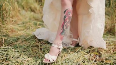 Bir dövme bacağını bir gelinlik altında gösterilen gelin. Bir kadın bir resim ile bir renkli dövme ve şaşırtıcı görmek