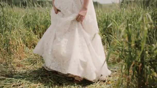 Mariée montre un tatouage coloré sur sa jambe. Elle soulève sa robe et commence à marcher dans un champ de blé .