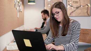 Çekici kız bir modern başlangıç ofis içinde laptop ile çalışma