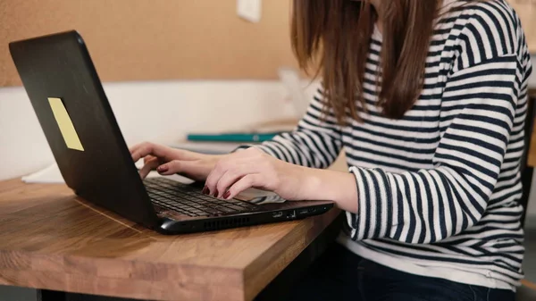 Closeup of the hands of young attractive girl uses a laptop in the modern startup office — Stock Photo, Image