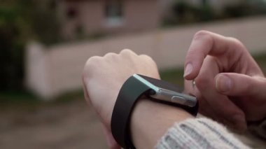 Onun smartwatch dokunmatik ekran cihaz bir kırsal arka plan üzerinde 4 k kullanan kadın