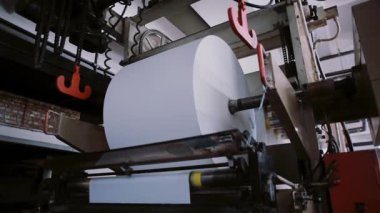 Baskı makine çalışma. Büyük bir rulo kağıt yayımlama. Üretim hattı ses ile kuruluş ayrıntılı baskı.