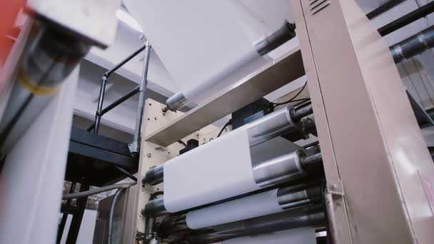 Carta nel processo di lavoro di una macchina da stampa. Dettaglio dello stabilimento di stampa sulla linea di produzione con suono . — Video Stock