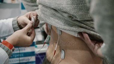 yakın çekim hemşire hasta arkadaki adam vücut üzerinde profesyonel Elektroterapi donanımları yükler.