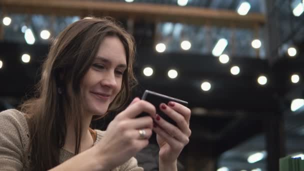 Closeup πορτρέτο. Γυναίκα με τη χρήση της συσκευής οθόνης αφής smartphon café σύγχρονο φώτα στο παρασκήνιο 4k — Αρχείο Βίντεο
