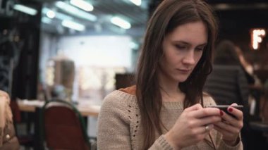 Portre portre. Onun smartphon dokunmatik ekran cihaz modern kafede 4 k kullanan kadın
