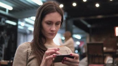 Portre portre. Onun smartphon dokunmatik ekran cihaz modern kafede 4 k kullanan kadın