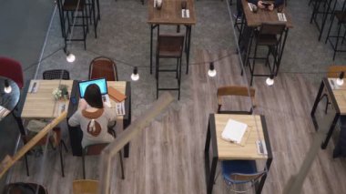 Üstten Görünüm. 4 k kafede dizüstü bilgisayar üzerinde çalışan iş kadını