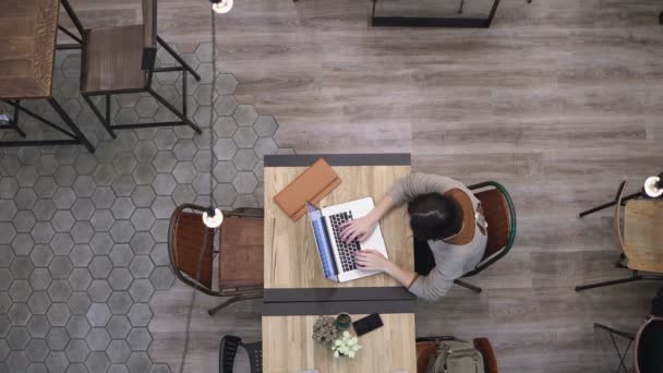 Vista superior. Mujer de negocios que trabaja en el ordenador portátil en la cafetería 4k — Vídeos de Stock