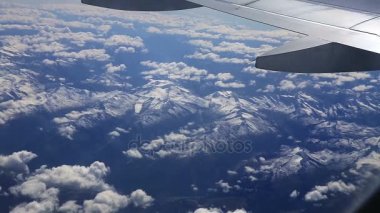 Uçan uçak penceresinden Dağların üzerinden. Yüksekliği güzel görünümünden dağ manzarası, hava yoluyla seyahat için
