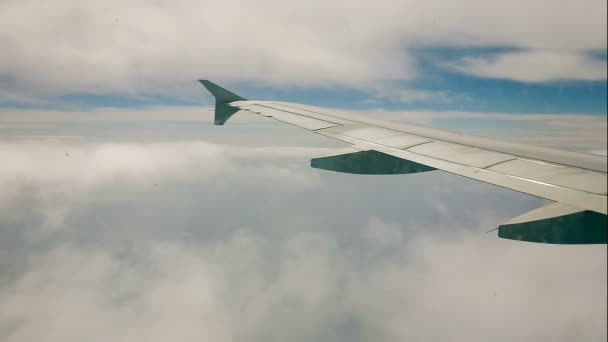 Viajando por aire en avión volando a través de las nubes. Vista a la gran cantidad de nubes desde el ojo de buey . — Vídeos de Stock