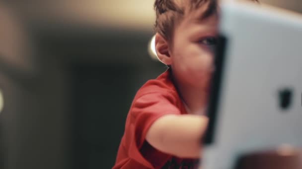 可爱的小男孩使用数字平板电脑上，微笑着用粉红色彩色铅笔绘图. — 图库视频影像