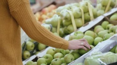 Yakın çekim kadın s el bir elma süpermarkette seçimi görünümünü, bir meyve tutan sonra geri koy. 4k
