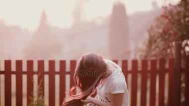 Dönme, eğleniyor, gülümseyen doğa, genç mutlu, neşeli bir kız. Saçlarını rüzgara sunset bulvarında çırpınır..