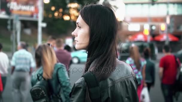 Νεαρή όμορφη γυναίκα που στέκεται στο δρόμο. Μελαχρινή γυρίζει και ψάχνει για την κάμερα. Αργή κίνηση — Αρχείο Βίντεο