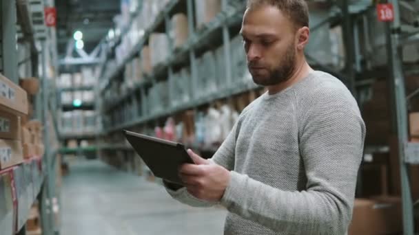 Junger Mann mit digitalem Tablet im Lager, Warenkontrolle im Supermarkt. 4k — Stockvideo