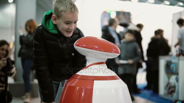 5 Kasım 2016 yılında Rusya, Moskova Robotik Expo. Küçük çocuk seyir özerk insansı robot ve onunla konuşayım. 4k — Stok video
