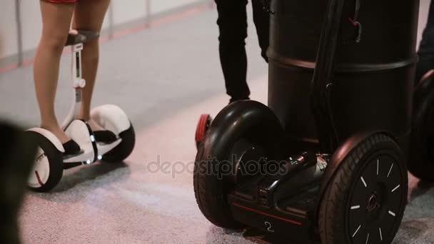 5 NOVEMBRE 2016 RUSSIA, MOSCA Robotica Expo. Ragazza e ragazzo s stanno cavalcando Segway, elettrico bilanciamento scooter bordo coperta — Video Stock