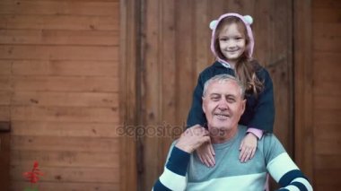 Dedesi ve hugs yaşlı adam ve gülümseme duran torunu. Kız bantları ve erkek elini öp. 4k