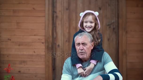 Little girl standing behind old man. Granddaughter hug grandfather, embracing shoulders. Female smiling and laughing. 4K — Stock Video