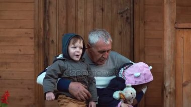 Ve dedesi s dizlerinin üstüne oturan kız. Yaşlı adam onun torunu ve torunu sarılmak. 4k
