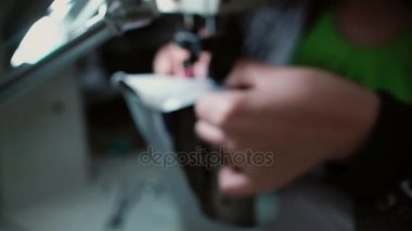 Giyim fabrika işçisi kumaş dikiş makinesi kullanarak diker. Deri kadın holding adet. Ayakkabı üretim. 4k
