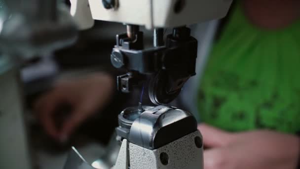 Primo piano della macchina da cucire. La donna cambia il filo e continua a lavorare in fabbrica. 4K — Video Stock