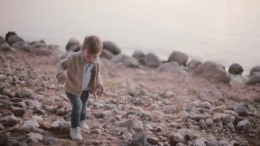 Sevimli küçük çocuk yakınındaki taş suda yürüme. Erkek buzlu düşer ve yükselir.