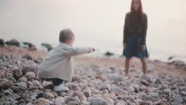 Un niño dando pasos sobre las rocas. Madre esperando hijo en la distancia y apoya al niño. Hombre cae pero se eleva y tratar . — Vídeo de stock