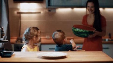 Ve masada oturan kız, genç anne yarım karpuz getiren ve masanın üstüne koy.