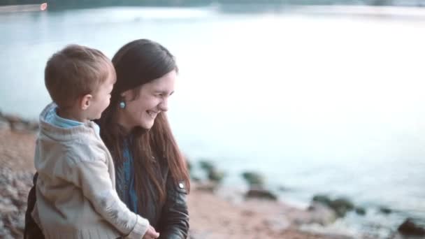 Madre e hijo pasando tiempo juntos en la orilla de la playa. Chico besos en la nariz, mujer feliz riendo . — Vídeos de Stock