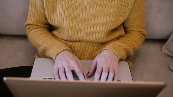 Γυναικεία χέρια που εργάζονται για το laptop κάθεται στον καναπέ στο σπίτι και πληκτρολογώντας. FOP θέα γυναίκα που κρατά τον υπολογιστή. — Αρχείο Βίντεο