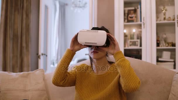 Jonge vrouw droeg Vr-headset thuis, rondkijken en nemen van de bril van virtual reality. — Stockvideo